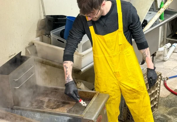 SaniDine crew member detailing kitchen equipment