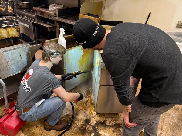 Two crew members cleaning equipment
